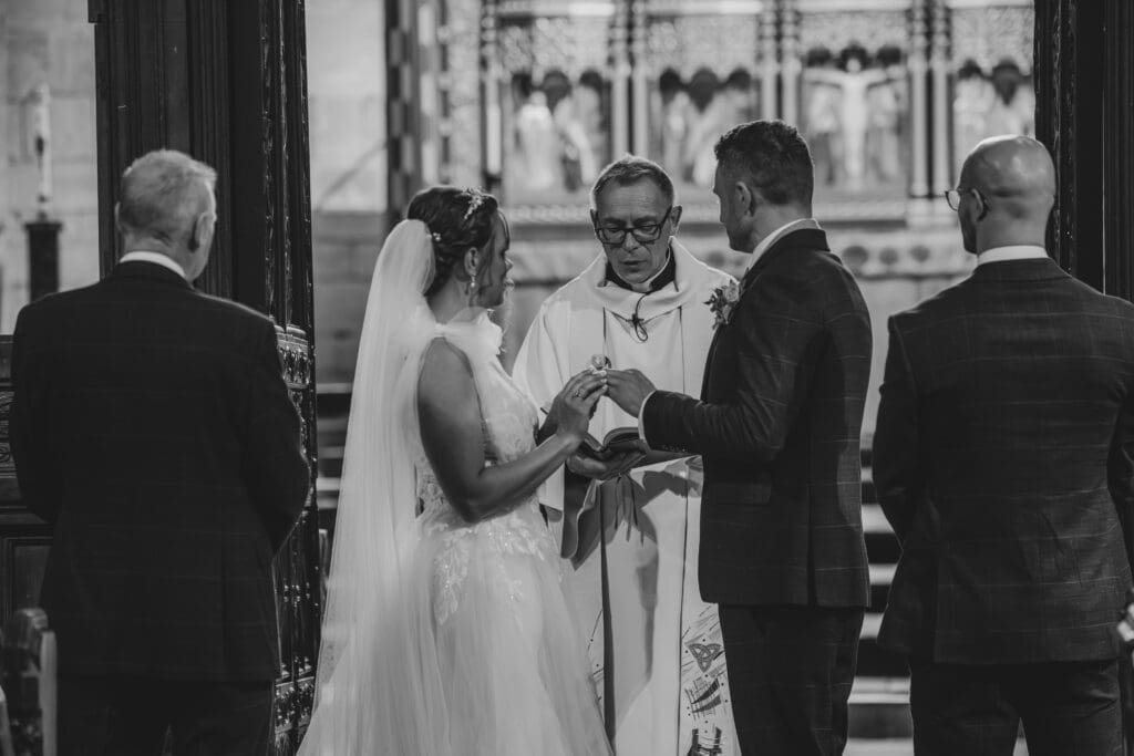 cartmel priory wedding ceremony, couple exchanging vows and rings