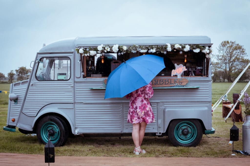 drinks van at wedding and girl with umbrella stood in front of it