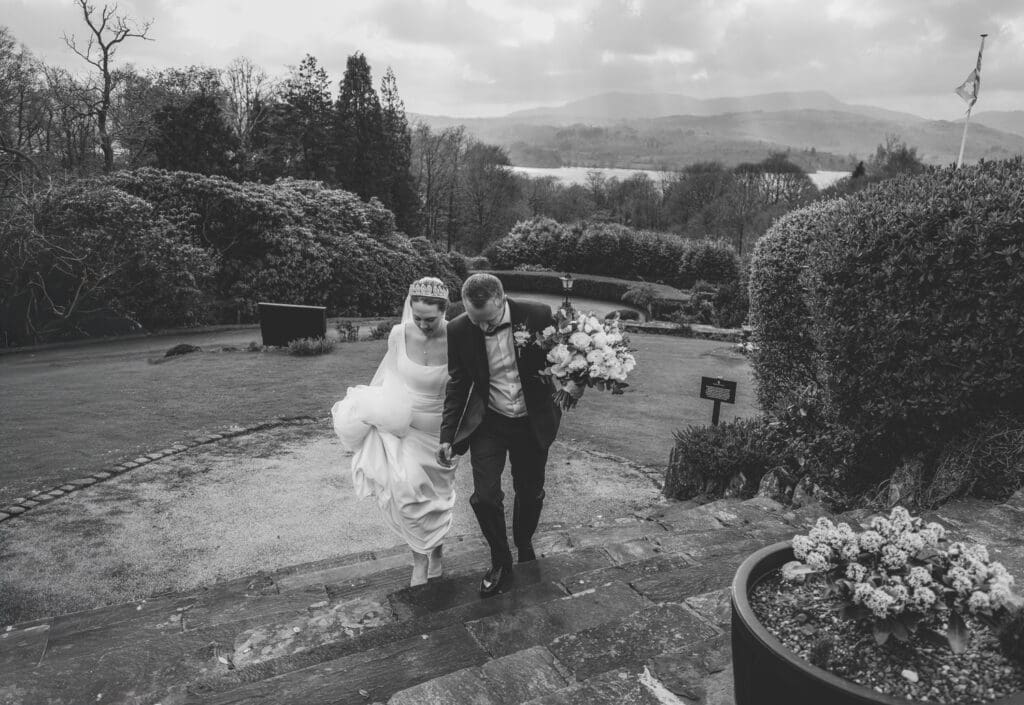 couple on wedding day walking up stairs of windermere hotel