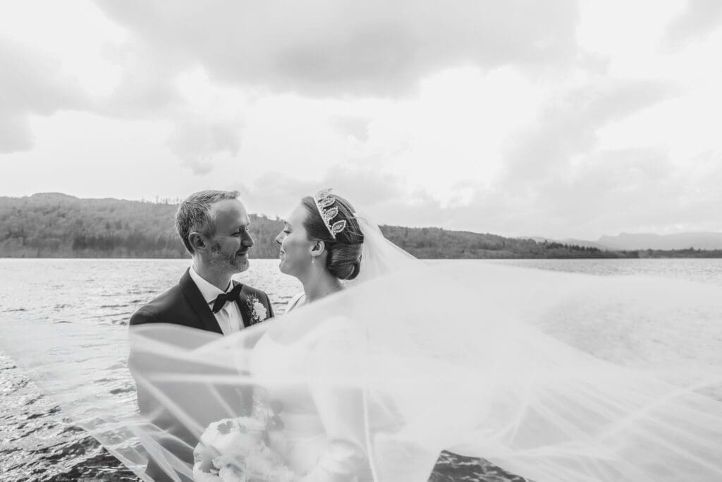 couple on wedding day in front of lake windermere